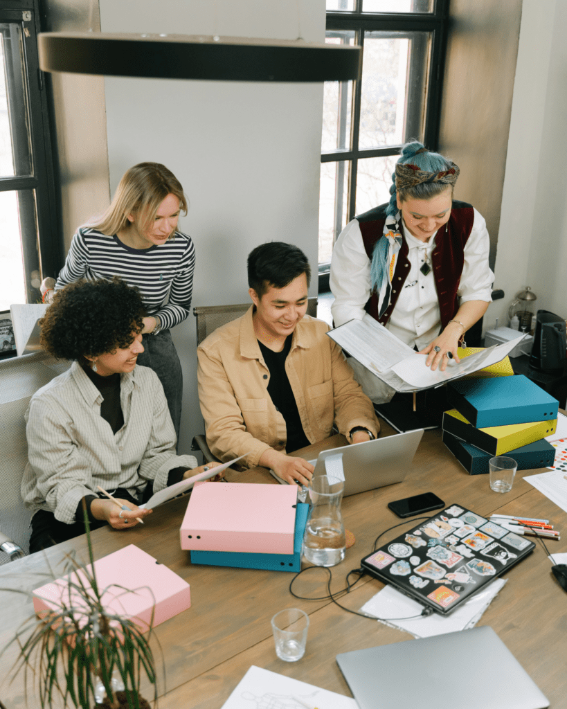 Communication inclusive - Une équipe de 4 personnes qui discutent autour d'un bureau.